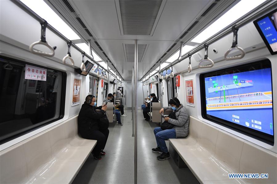Students play online games inside a subway train in Beijing